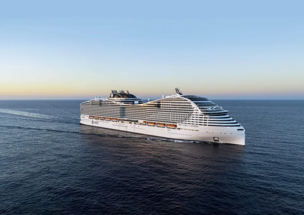 MSC World Europa cruiseschip op zee tijdens zonsondergang met kalm water